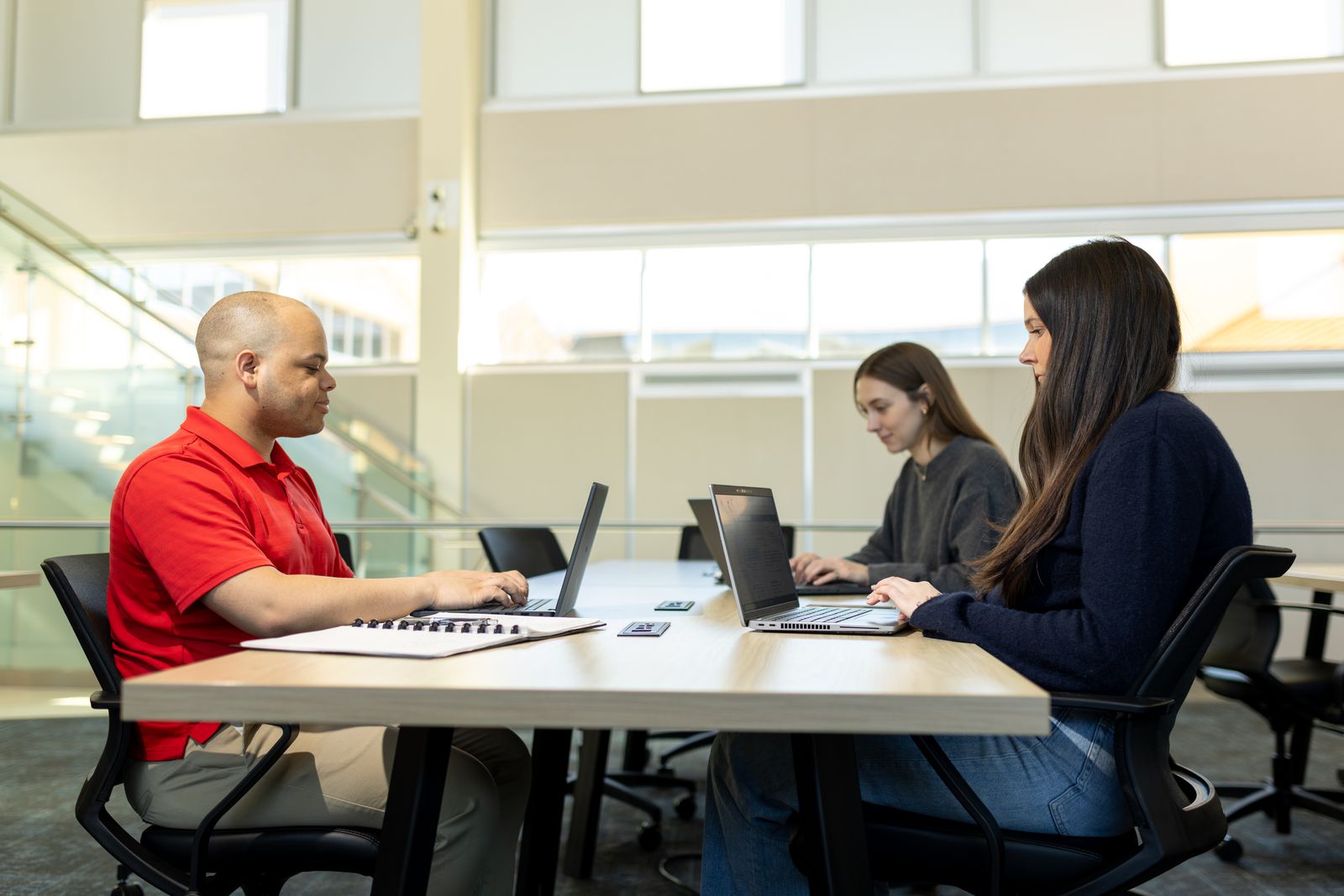 Logan University students working on laptops in a campus study space