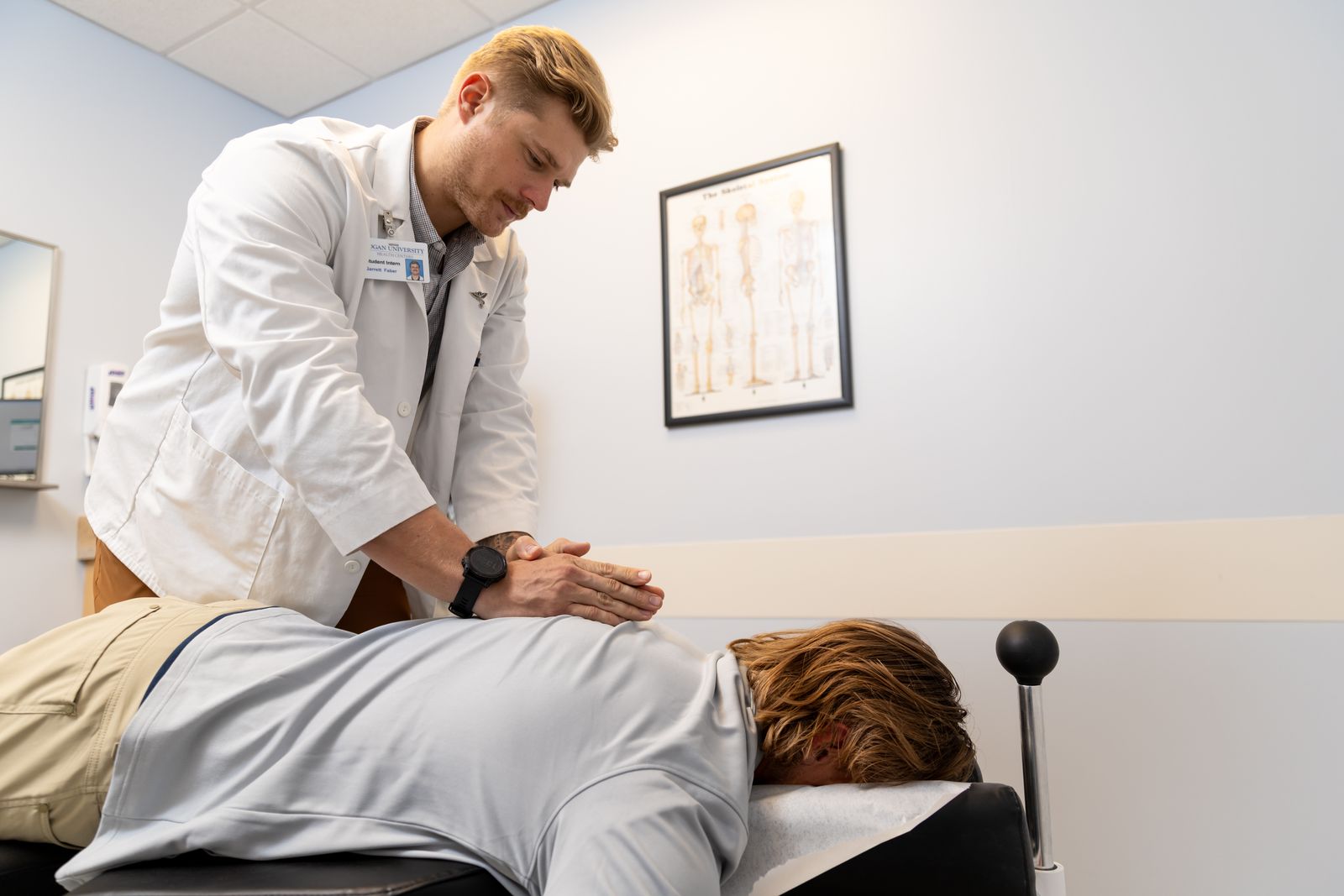 A Logan clinician adjusts a patient lying face down on a treatment table