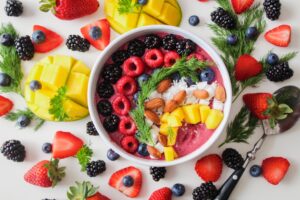 Un tazón de fruta se sienta en una mesa