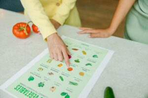 Una mujer señala un gráfico con imágenes de frutas y verduras